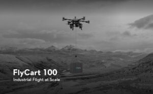 The Flycart 100 delivery drone in flight carrying a heavy cargo payload.