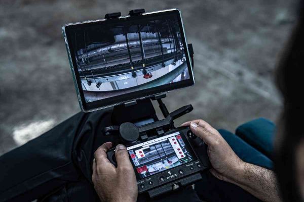 Operator inspecting a confined space with Flybotix drone and Flystation
